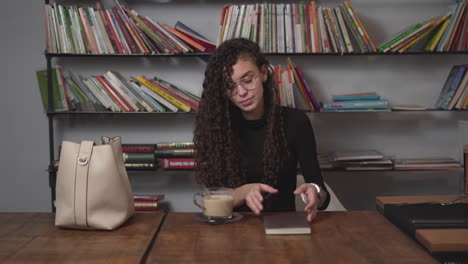 mujer leyendo y bebiendo café en una cafetería