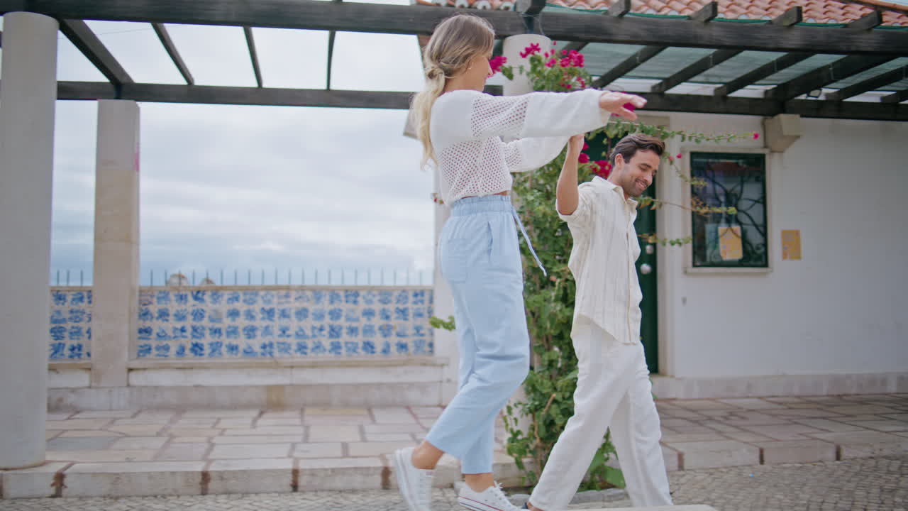 사랑에 빠진 커플이 바다 풍경 거리를 고, 남자가 부드럽게 손에 여자를 들고 있다.