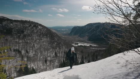 Caucasian-Girl-Hiking-Up-A-Steep-And-Snowy-Mountain-Slope-In-Mont-Du-Dome-Canada---wide-shot
