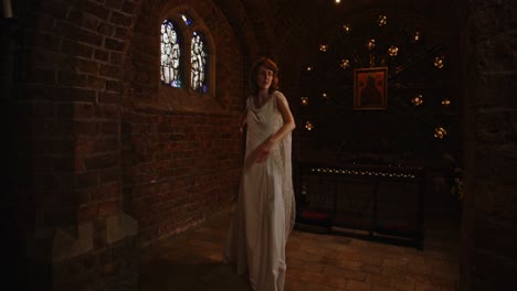 woman in a beautiful long dress dancing in an old chapel