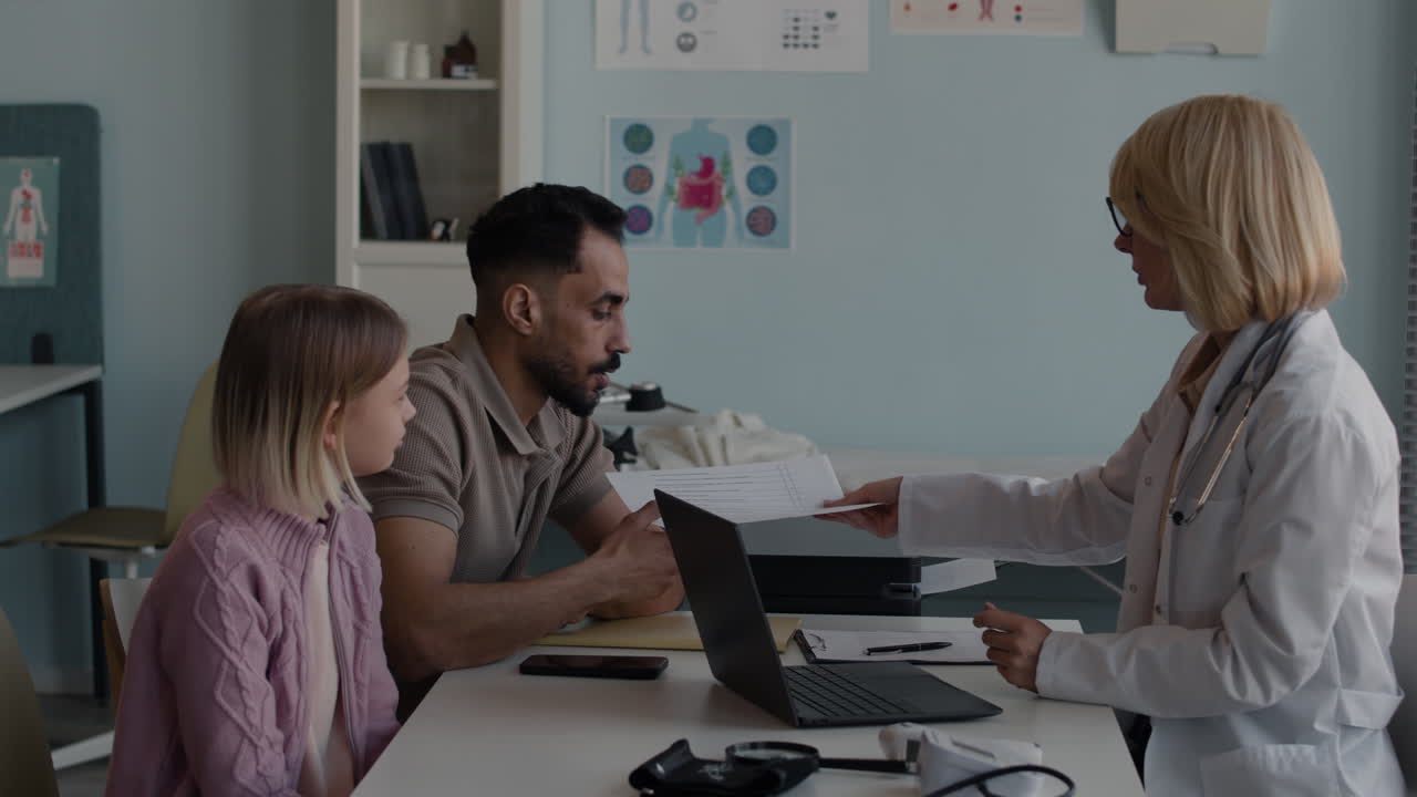 Doctor consulting with a father and daughter