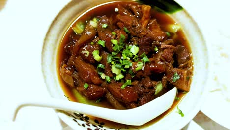 un guiso de carne salada adornado con hierbas frescas