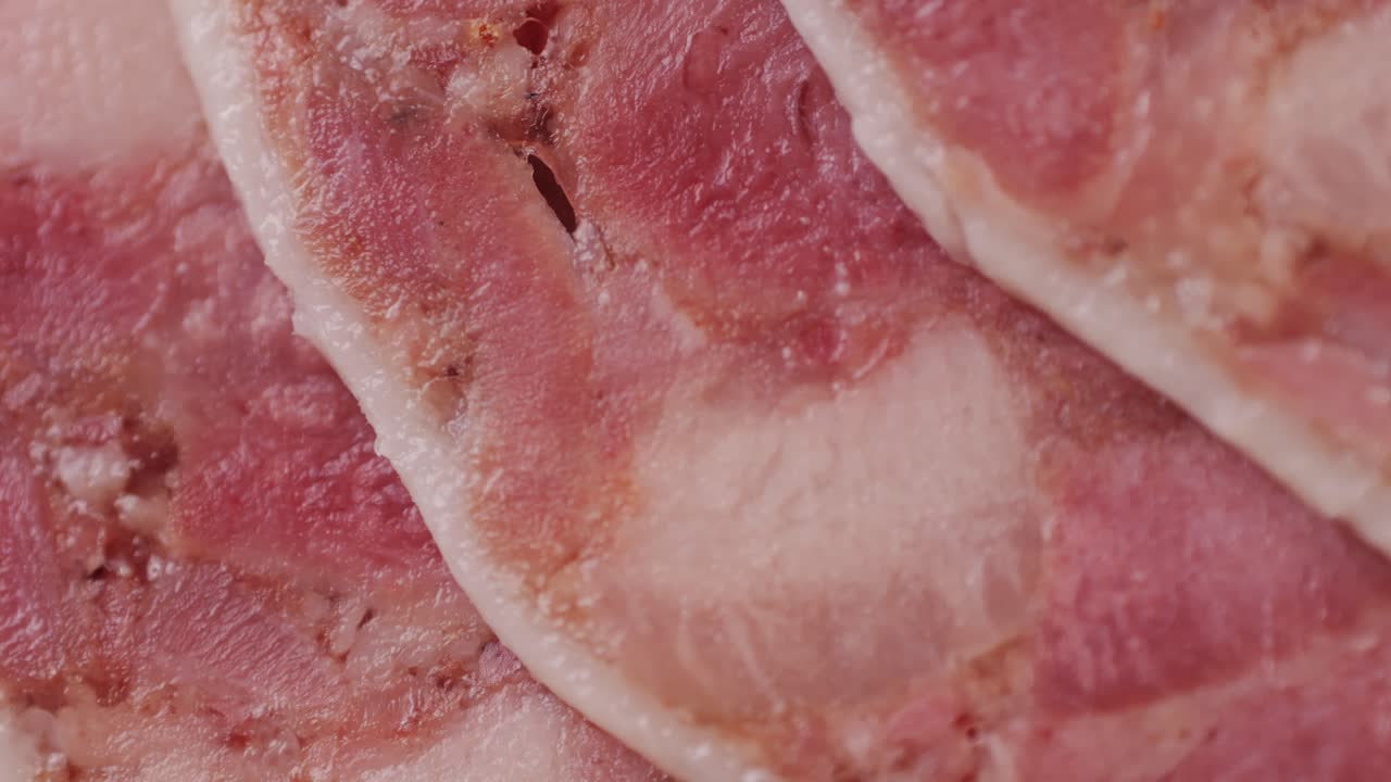 black bull sausage ham, tongue pork dry-cured sausage on a black background, traditional spanish delicatessen food, close up.