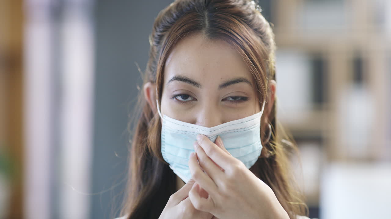 얼굴 마스크를 조정하는 여성
