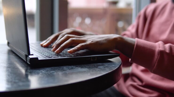 Mann arbeitet mit dem Laptop im Restaurant. Nahaufnahme einer Männerhand.