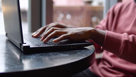 man working with the laptop in the restorant. close-up of a man's hand