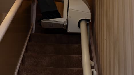 middle aged man, of african ethnicity, using a residential stair lift