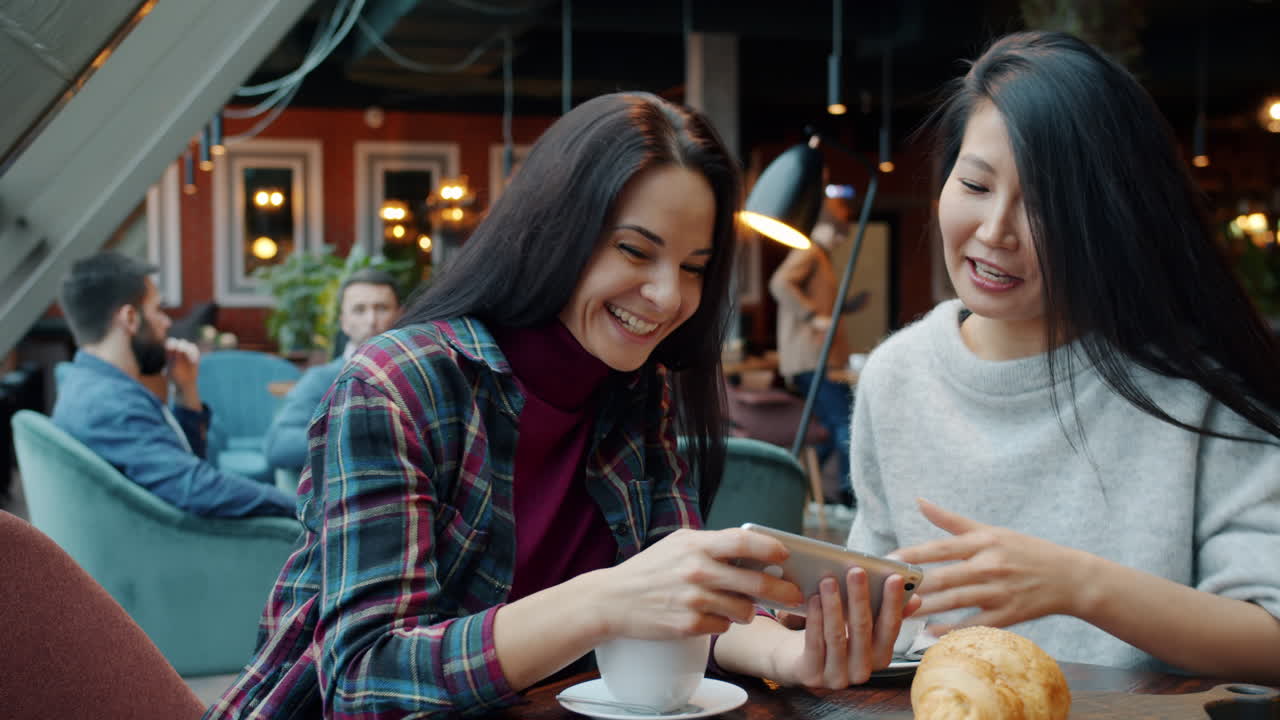 Two Women Friends Enjoying Coffee and a Phone Moment in a Cafe