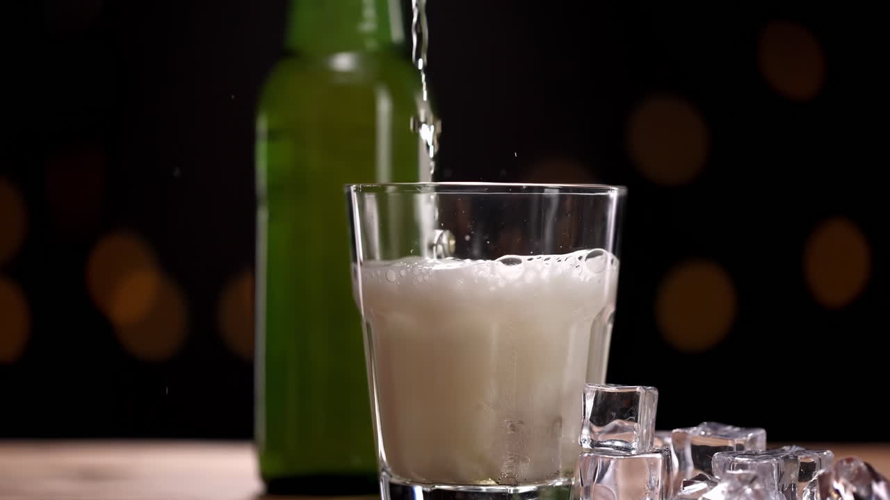 Lezzetli içeceklerden şarap, şampanya, bira şişesinden bardağa dökülürken yakın çekim, soğutulmuş buğday veya lager bira köpüğünün kabarıp taşması, siyah zemin üzerinde ferahlatıcı sıçrama