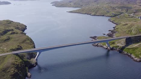 tilting, wide angle drone shot of the bridge connecting the isle of scalpay to the isle of harris on the outer hebrides of scotland