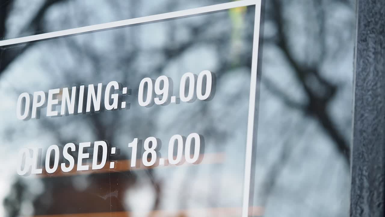 Opening and Closing Times Sign on Glass Door
