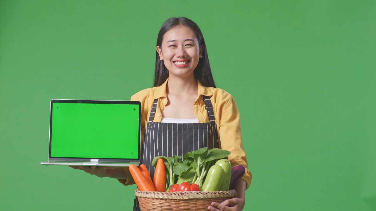 온라인 판매를 위해 신선한 채소와 노트북을 전시하는 여성 농부