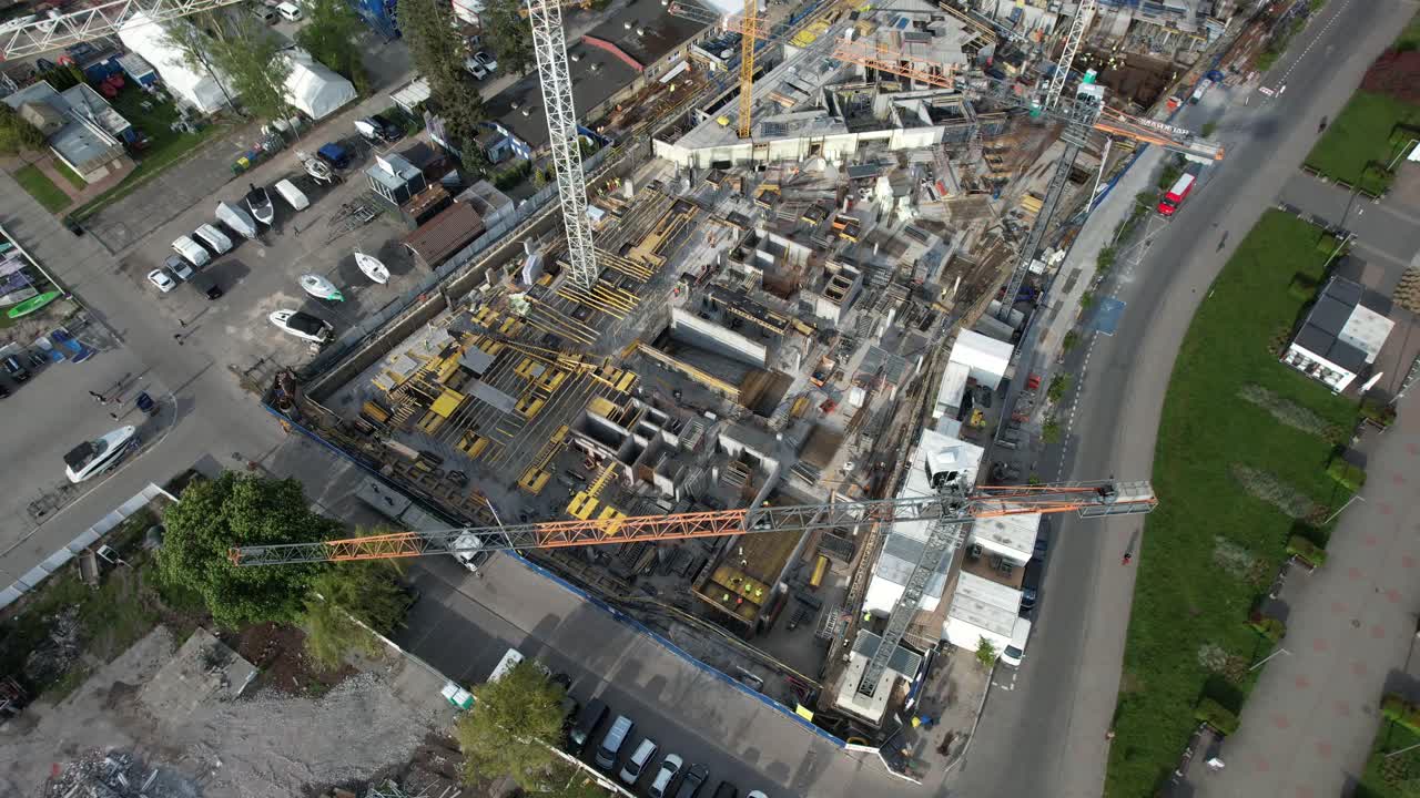 Construction in progress with cranes and equipment. Aerial view of building site