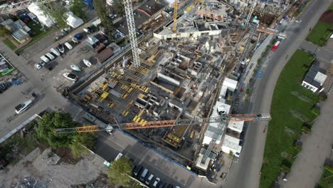construction in progress with cranes and equipment. aerial view of building site