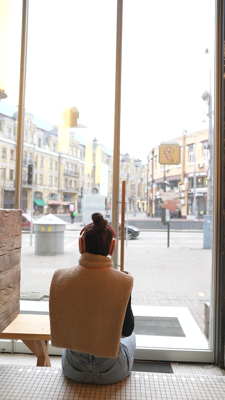 mujer disfrutando de café y vista de la ciudad en una cafetería