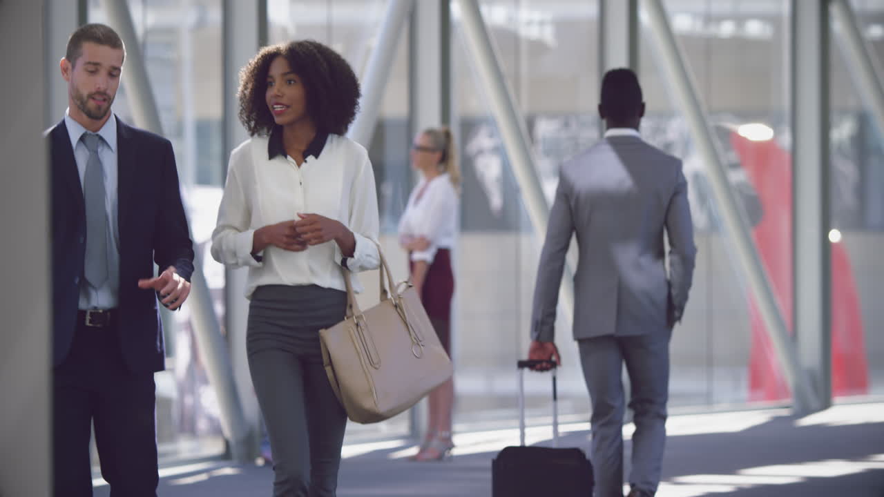 Business people interacting with each other in the corridor at office 4k
