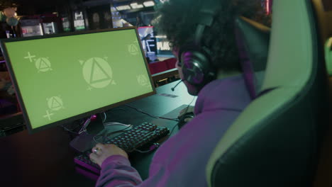 Rear-View-Of-An-Male-Gamer-Playing-Virtual-Video-Games-On-Professional-Powerful-Computer-With-Green-Screen-Display