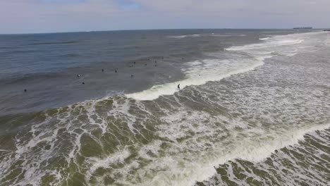 Birds-eye-view-of-surfers-on-their-surf-boards,-floating-on-surface-of-vast-endless-sea