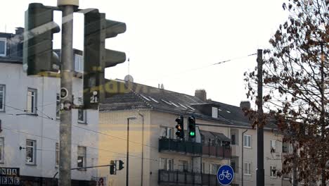 Ampel-In-Einer-Deutschen-Stadt-Hinter-Einem-Fenster,-Das-Von-Grün-Auf-Rot-Wechselt