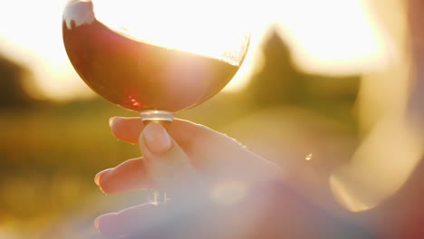 holding wine glass at sunset