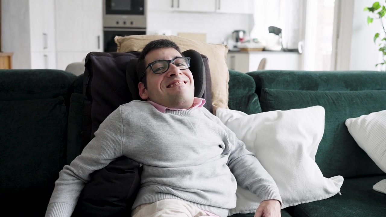 Giovane uomo con disabilità che si rilassa sul divano a casa