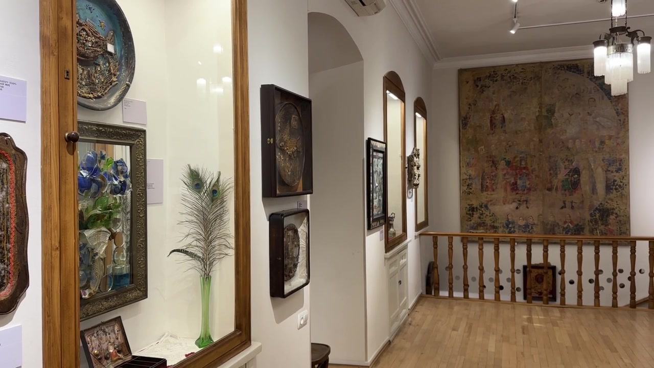 Design d'interni vintage a Yerevan, Armenia: scala in legno con ringhiera, tappeto persiano/iraniano, arte murale incorniciata e motivi tessili tradizionali, patrimonio rustico, accogliente galleria museale.