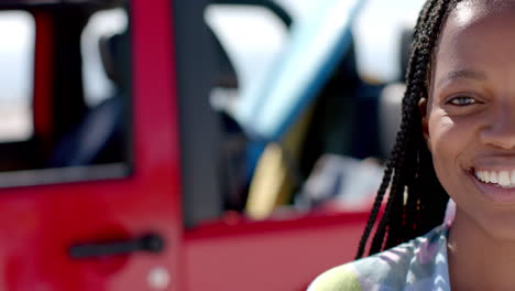 Young-African-American-woman-smiles-brightly-outdoors-on-a-road-trip,-with-copy-space