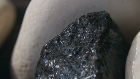 throwing water on hot stones in the sauna stove, close up of water splashing and evaporating into steam, heating the sauna