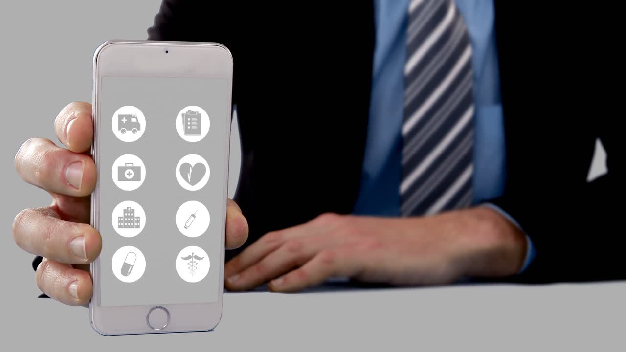 sección media de un hombre de negocios que muestra un teléfono móvil con iconos