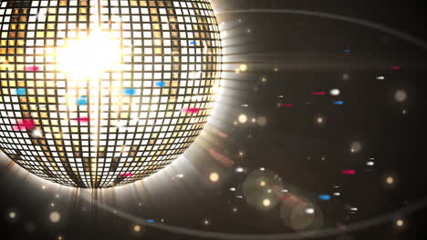 animación de una bola de discoteca iluminada que gira con el destello de la lente sobre un fondo negro