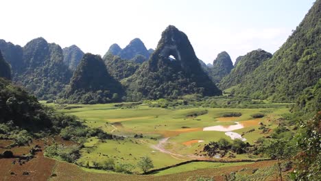 breathtaking-view-of-the-mountains-in-Cao-Bang-North-Vietnam-with-horses-in-a-field-and-an-eye-in-the-mountains,-stabilized-shot