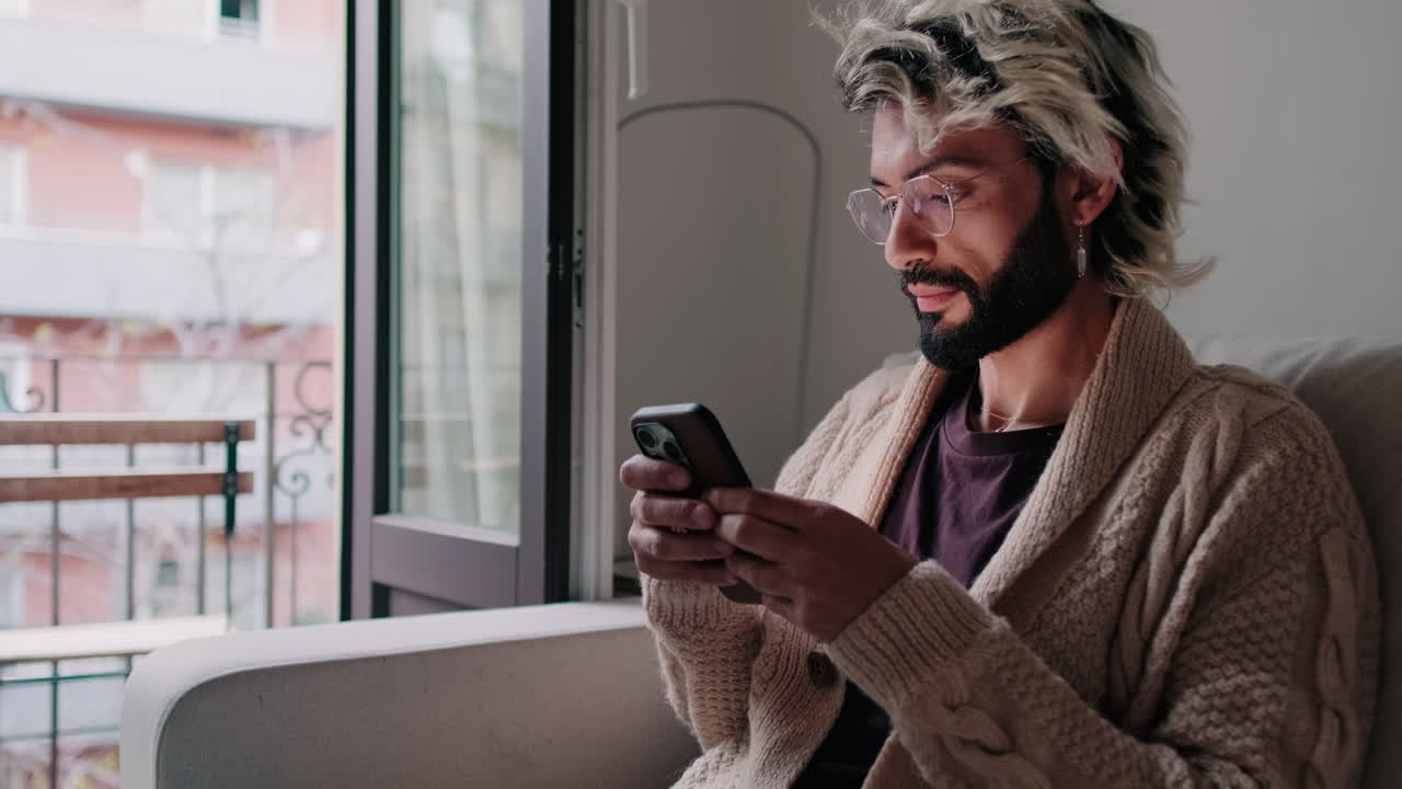 Young man or gay at Home Using Phone