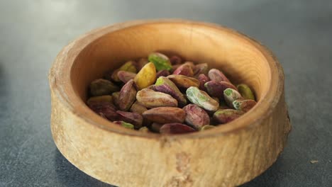 close-up of pistachios in a wooden bowl