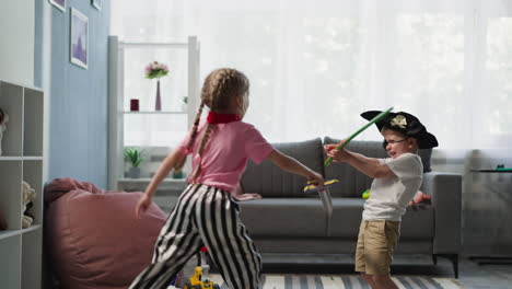 Toddler-and-preschooler-girl-play-with-toy-swords-at-home