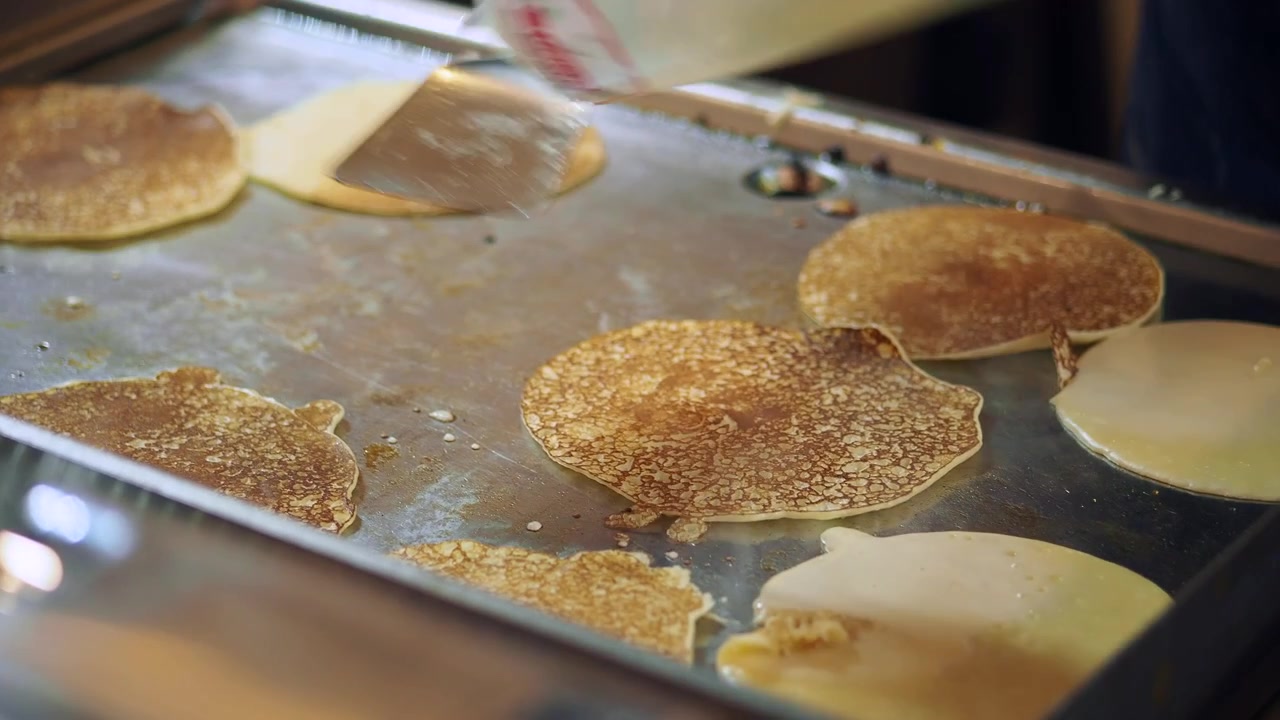 Chef Flipping Golden Pancakes on a Hot Griddle