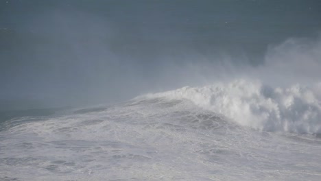 huge waves crashing at nazare, portugal, creating a powerful and dramatic ocean scene