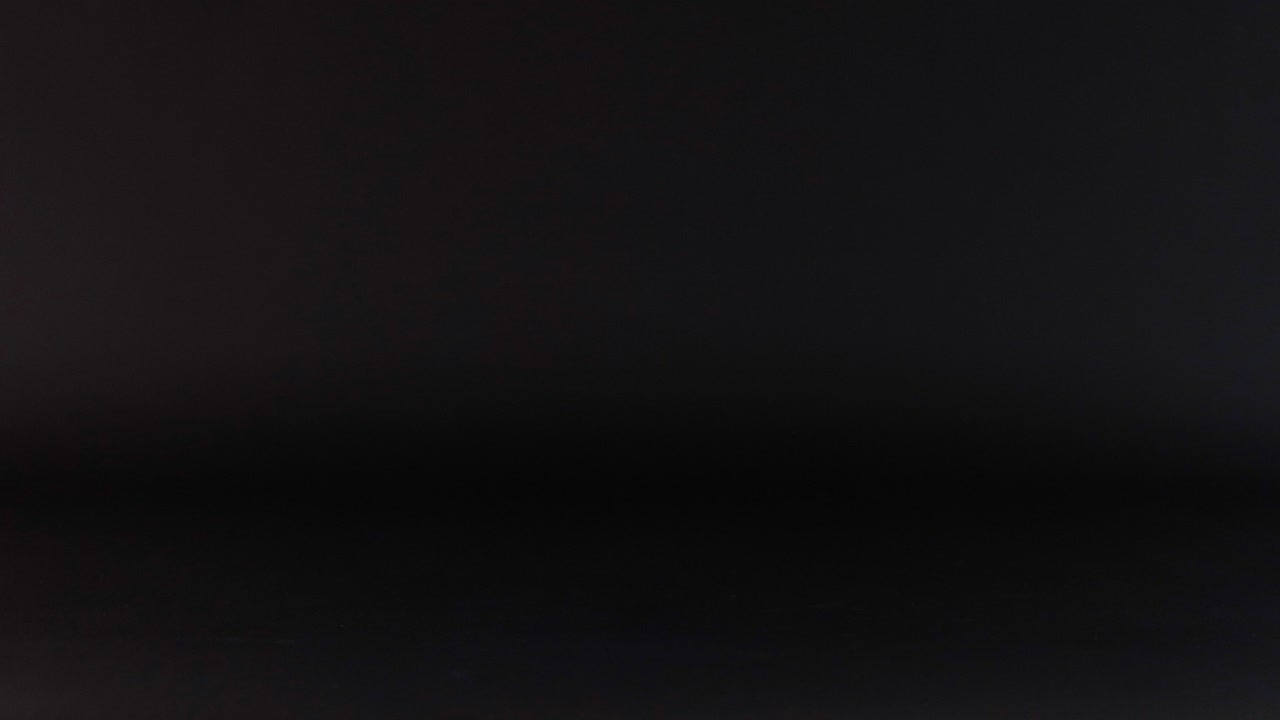 una pelota púrpura rodando a través de una superficie oscura