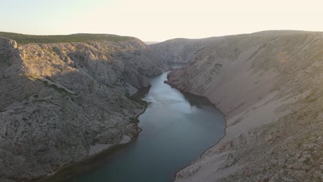 Hora-Dorada-Cinematográfica-De-Drones-Con-Una-Pareja-Joven-Parada-Sobre-Un-Acantilado-En-El-Cañón-Zrmanja,-Croacia