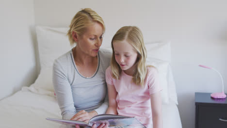 Vista-Frontal-De-Una-Mujer-Caucásica-Leyendo-Un-Cuento-A-Su-Hija-En-La-Cama.