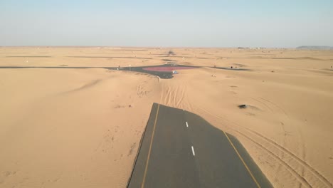 vista aérea desde drones de carreteras abandonadas del desierto cubiertas de dunas de arena en dubai, emiratos árabes unidos