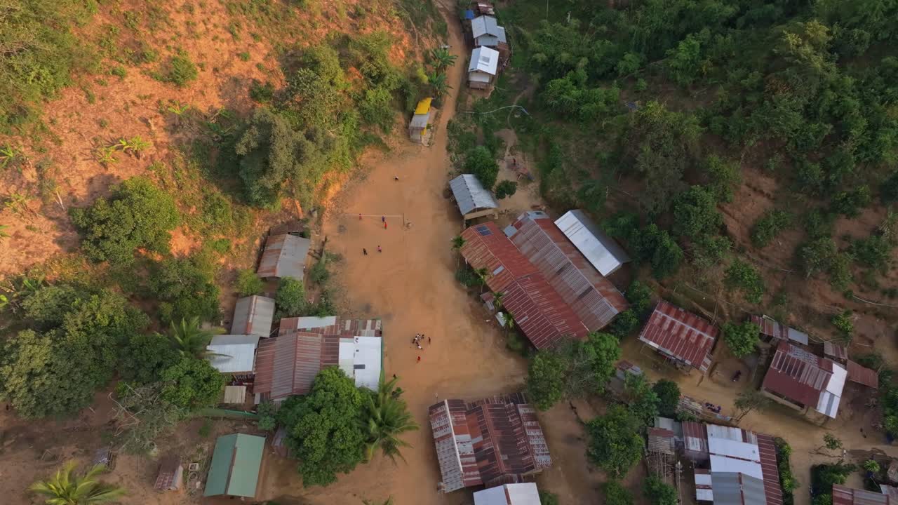 Aerial shot of rural Thai homes amid tropical landscape, Thailand