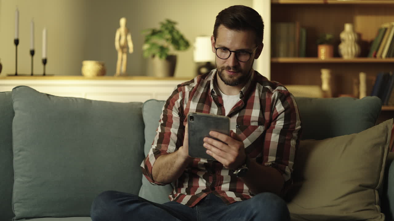 hombre usando tableta en el sofá