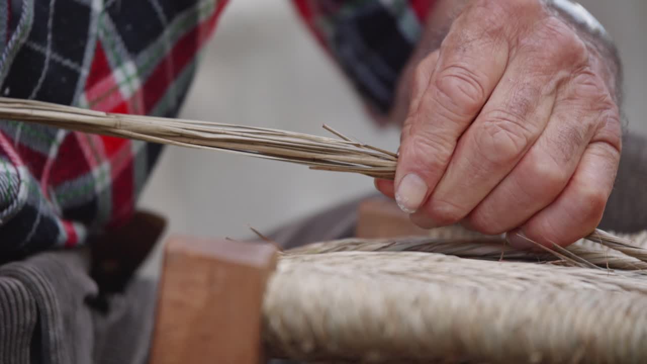 vista de cerca de la técnica de tejer sillas con la mano de un anciano, italia.