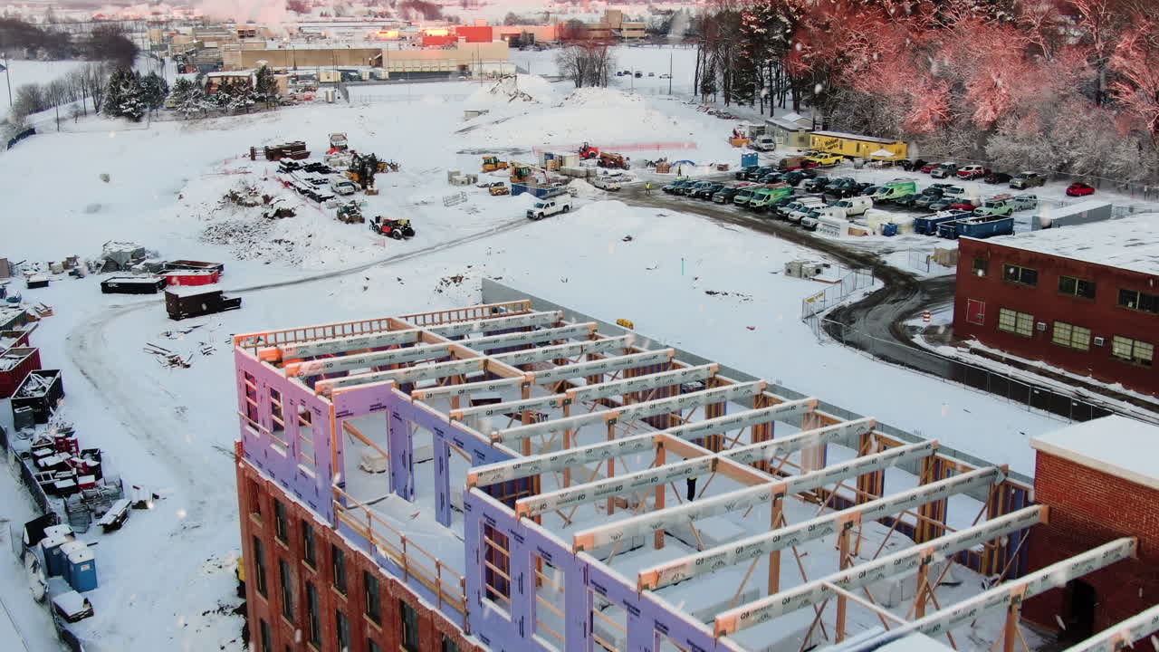 toma aérea de establecimiento sobre el edificio para revelar un aparcamiento cubierto de nieve.