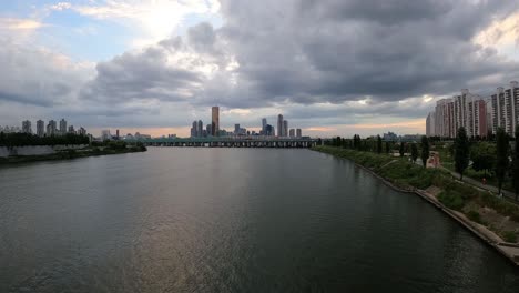 cloudy sky over han river in seoul, south korea with railway bridge and city skyline in distance