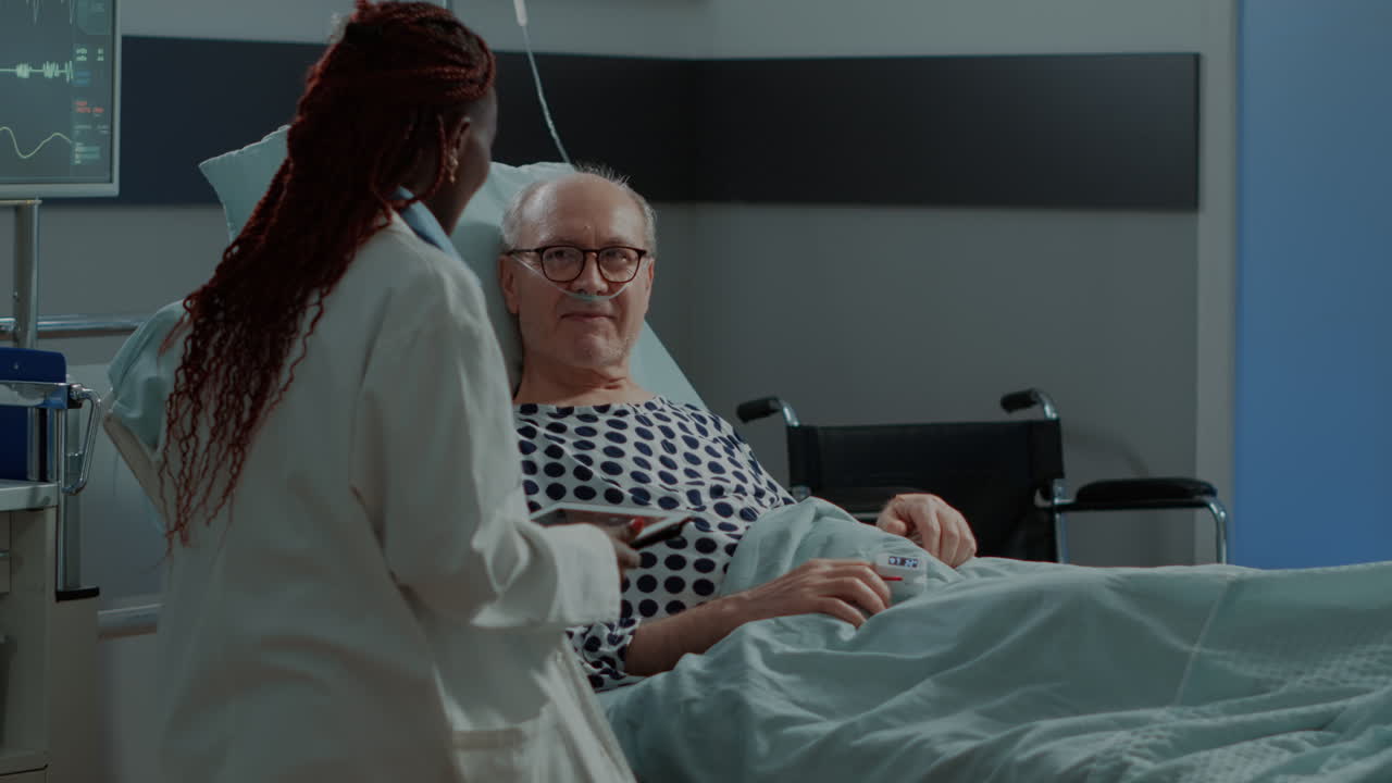 Multi ethnic medical personnel and patient in hospital ward