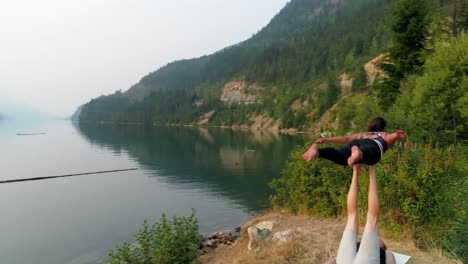 women practicing acroyoga near lakeside 4k