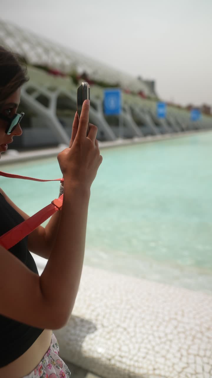mujer tomando una foto junto a la piscina