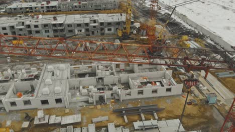 orange construction crane against unfinished buildings