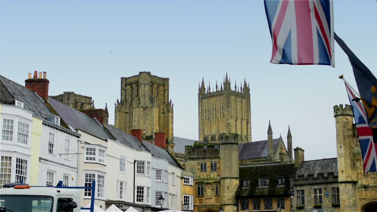 union jacks revolotean en el primer plano de esta vista típicamente inglesa a través de wells market place hacia la catedral, en la ciudad más pequeña de inglaterra